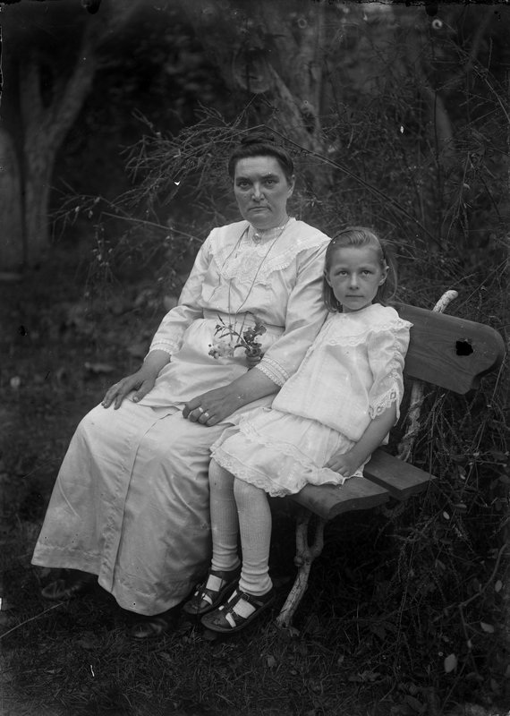 Naine ja tüdruk istumas pingil