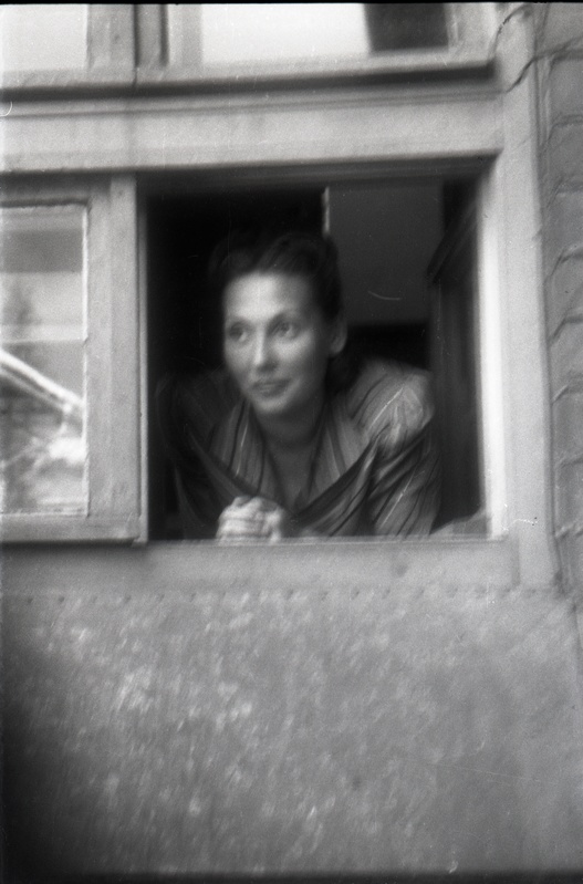 Naine väiksest aknast välja vaatamas