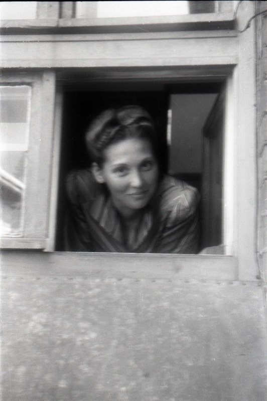 Naine väiksest aknast välja vaatamas