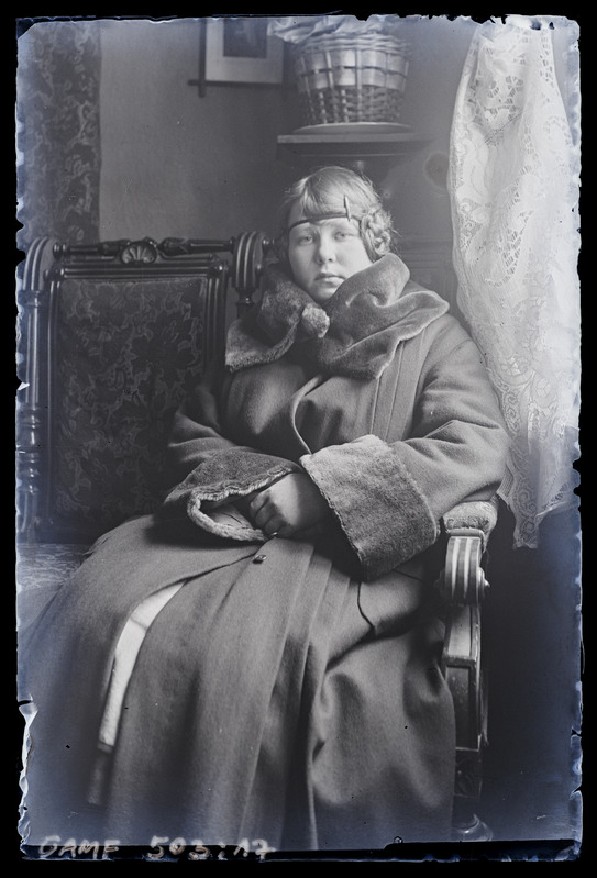 Naise portree. Talveriietes toas toolil istumas