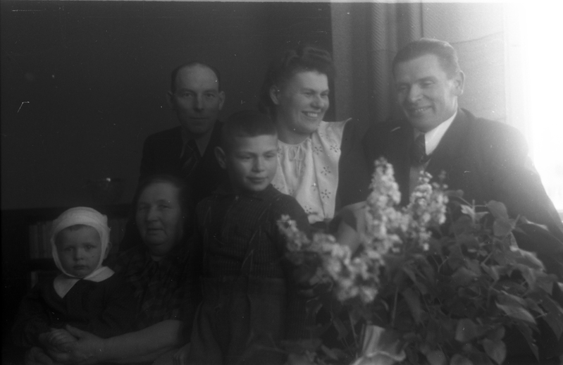 TRÜ psühhiaatriakateedri juhataja (1941–1975), arstiteaduskonna prodekaan ( 1944–1949)  Elmar Karu (paremalt esimene), abikaasa Leida Karu (paremalt teine), naine, mees ja kaks last lillede taga istumas