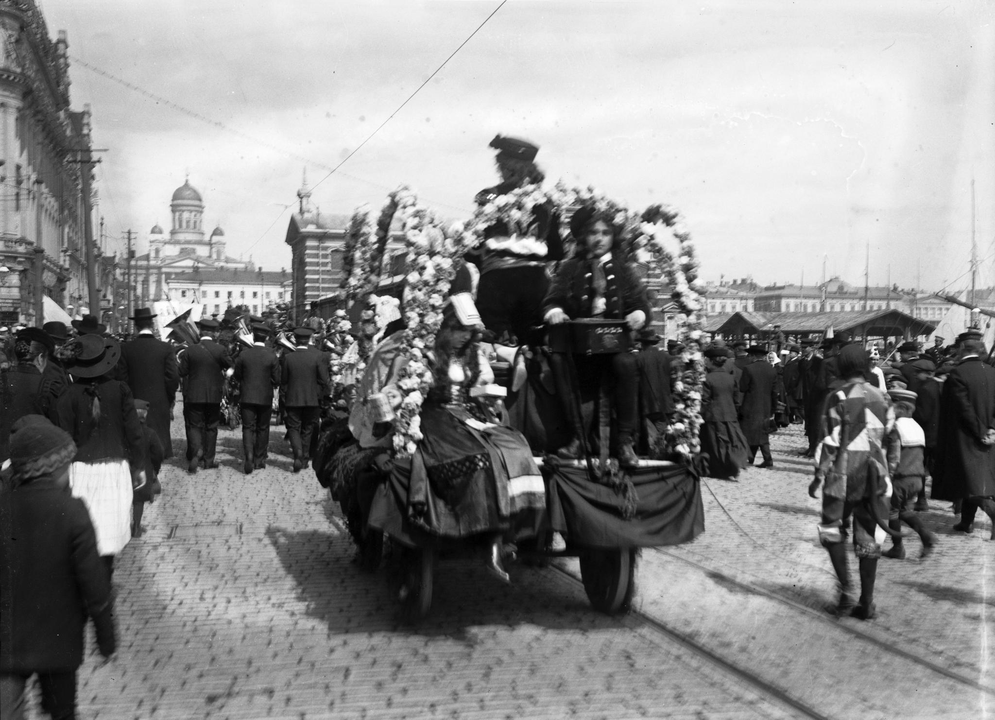 Parad med blåsorkester och blomterprydda hästvagnar  ... (1890-1910)