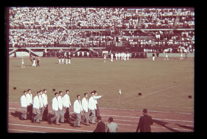 Üliõpilasspordipidu Viinis 1939, avamisüritus. Grupp valgeis rõivais inimesi staadionil.