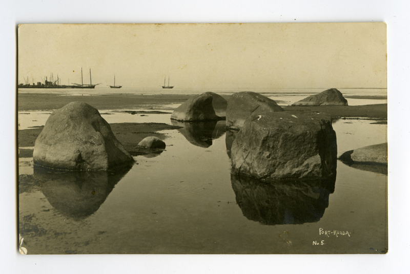 Large stones on the beach of Kunda. The port of Kunda appears in the back.