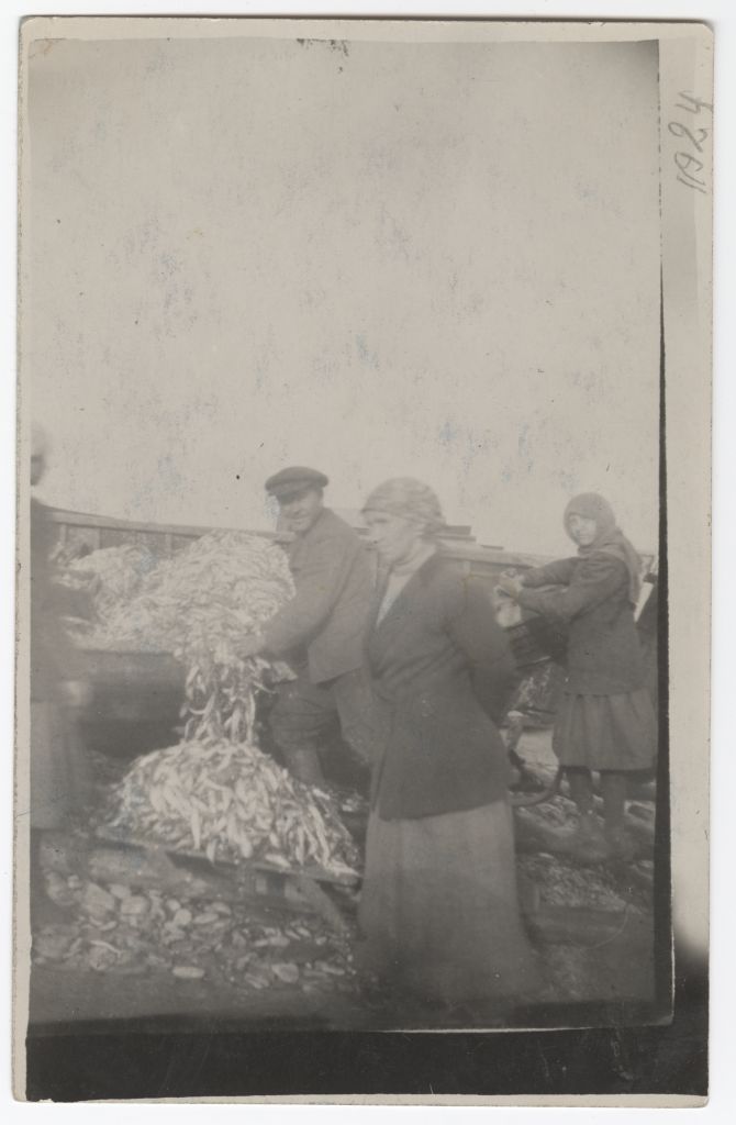 Fishermen and fish buyer Aksinja Tsvetkova Toila beach with fish filled with fishing boats