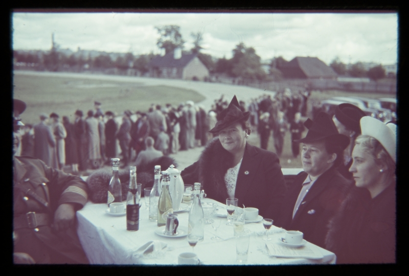 Three women with hats behind the table. On the right Jenny Koitmets (Johannes Koitmetsa husband), background viewers near the hypodrome.