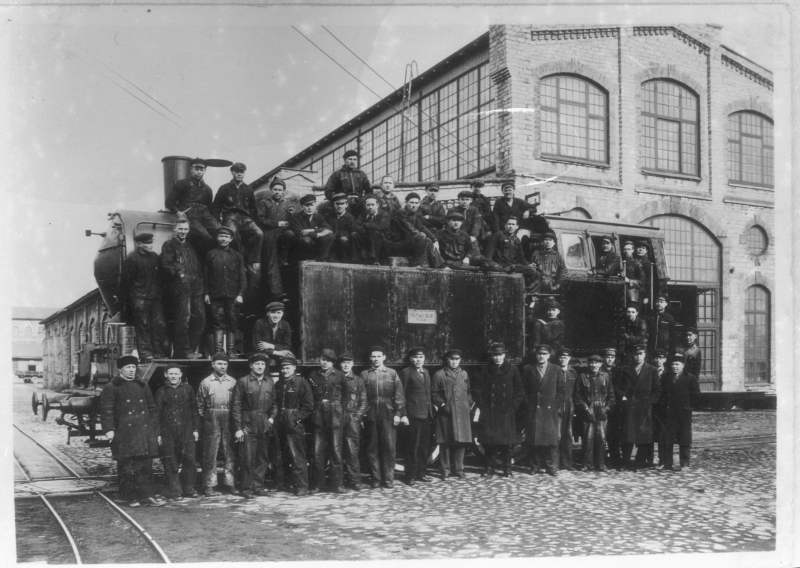 Group picture: first, the wide-ranging locomotive and the workers of the factory released by the as Franz Krulli machine factory.