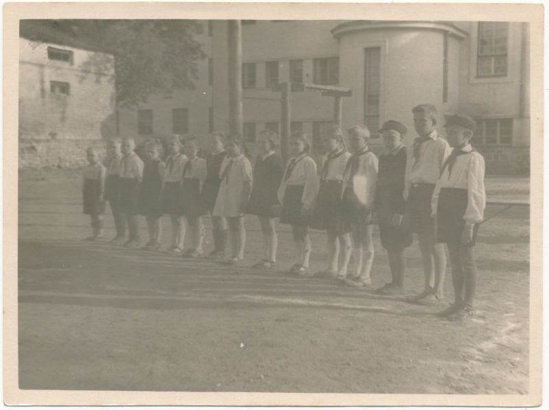 Photo. Pioneers in line at the school house courtyard.