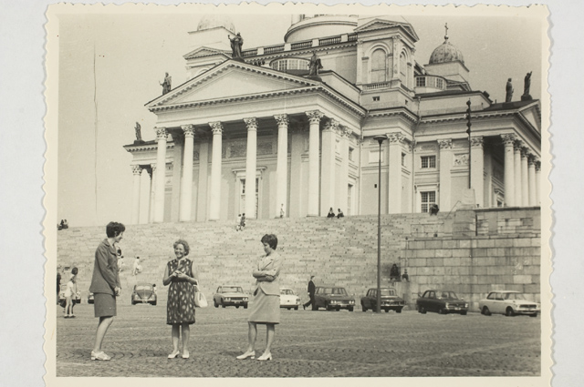 Tourists at the Senate Square in Helsinki, background Toomkirik