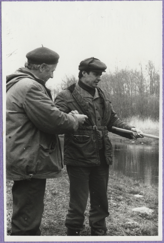 Haapsalu Kalakaitse Inspektsiooni tööd. Kaks meest jõekaldal, ühel käes õngeritv.