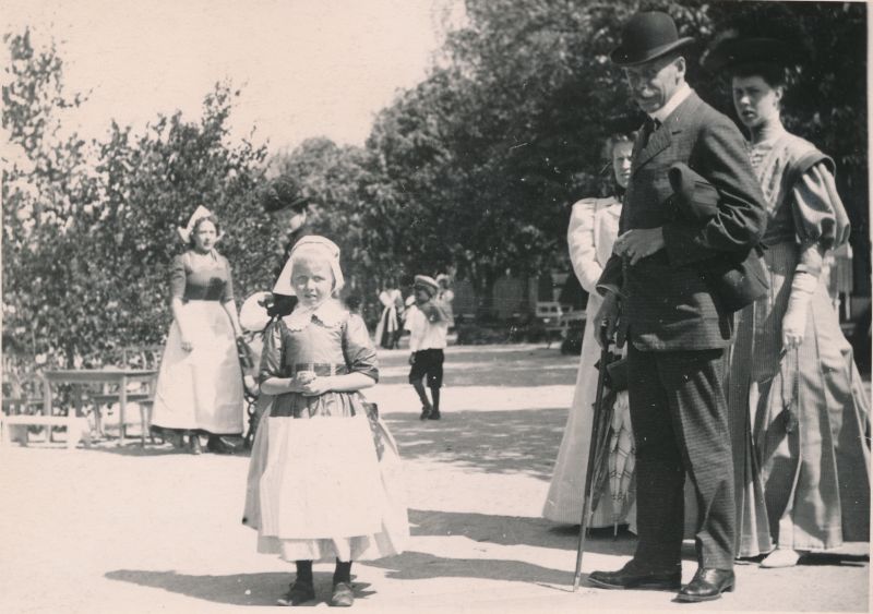 Foto. Vaade Haapsalu Suurele promenaadile. Paremal grupp suvitajaid, keskel tütarlaps hollandi rahvarõivais. Foto ca 1910.