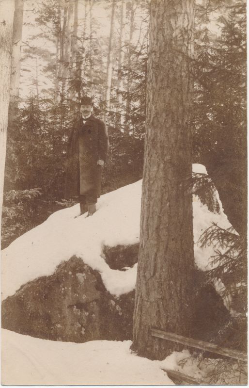 Foto. Mees seismas metsas suurel kivil. O. Siluti kogu. Albumis.