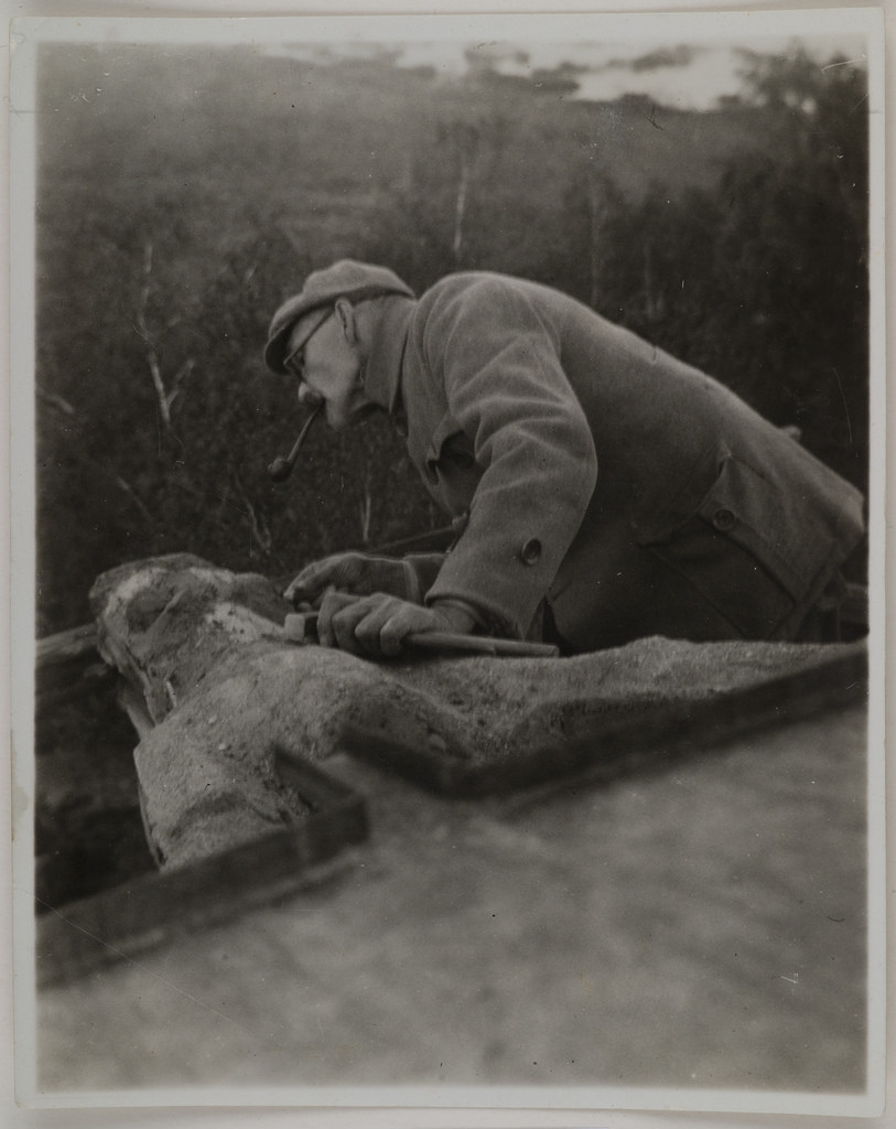Akseli Gallen-Kallela on the town of Tarvaspää working on a dragon-shaped gargoyle, 1927; photograph 2.