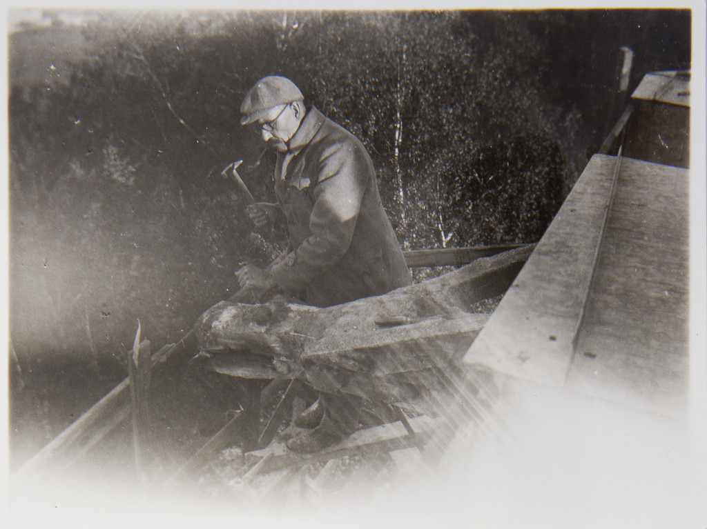 Akseli Gallen-Kallela on the tower of Tarvaspää working on a dragon-shaped gargoyle, 1927; photograph 5.