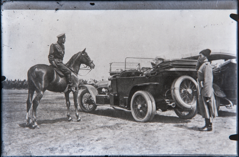 Vene tsaar Nikolai II hobusel, kõrval sõiduautod.