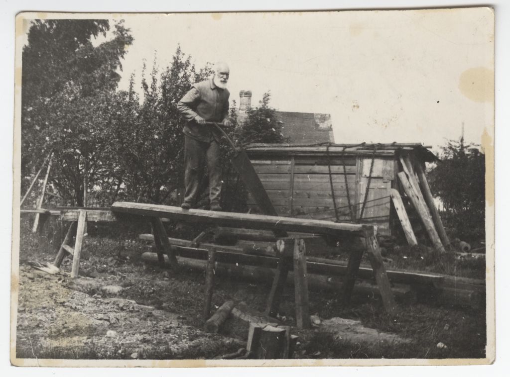 Jaan Warik saagimas käsitsi suure saega palgist prussi.