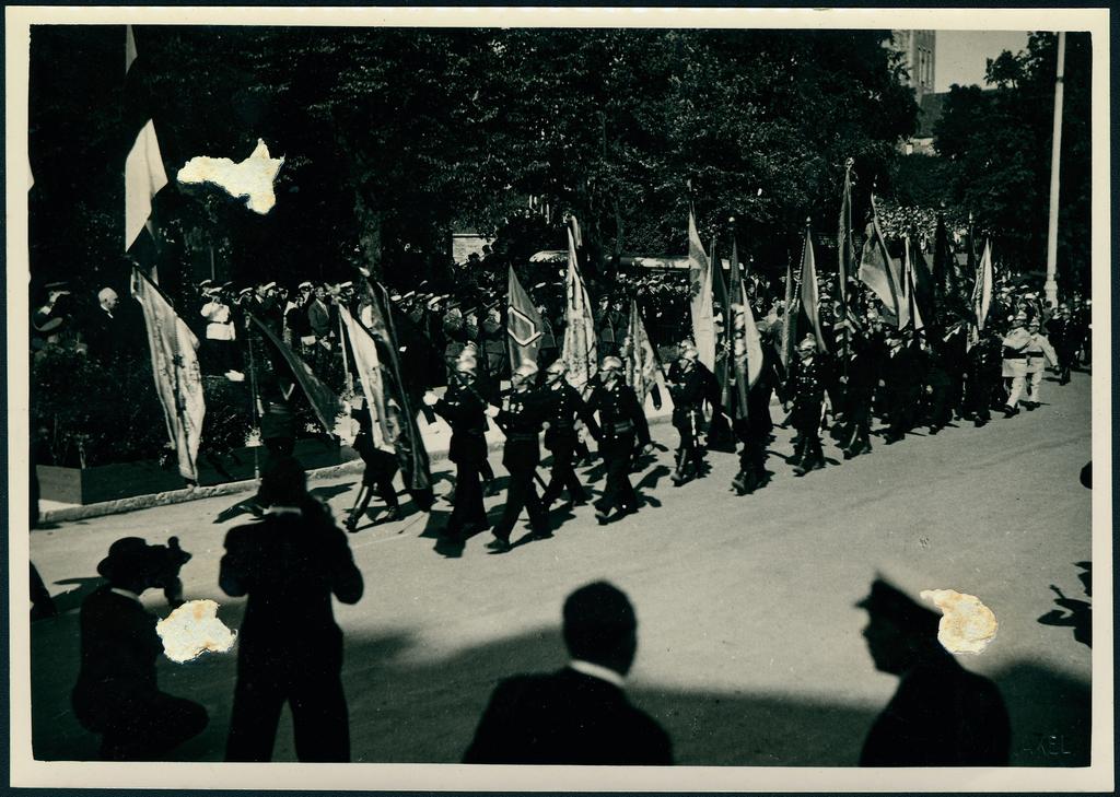 Tuletõrjujate kolonn paraadil lippudega marssimas