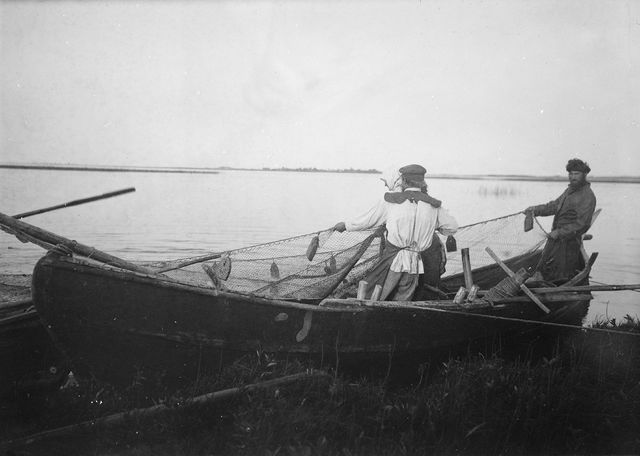 Russian fishermen pull the boat on the beach of Lake Peipsi