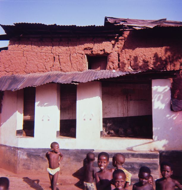 Culture building and the children of the village in front of it; overview