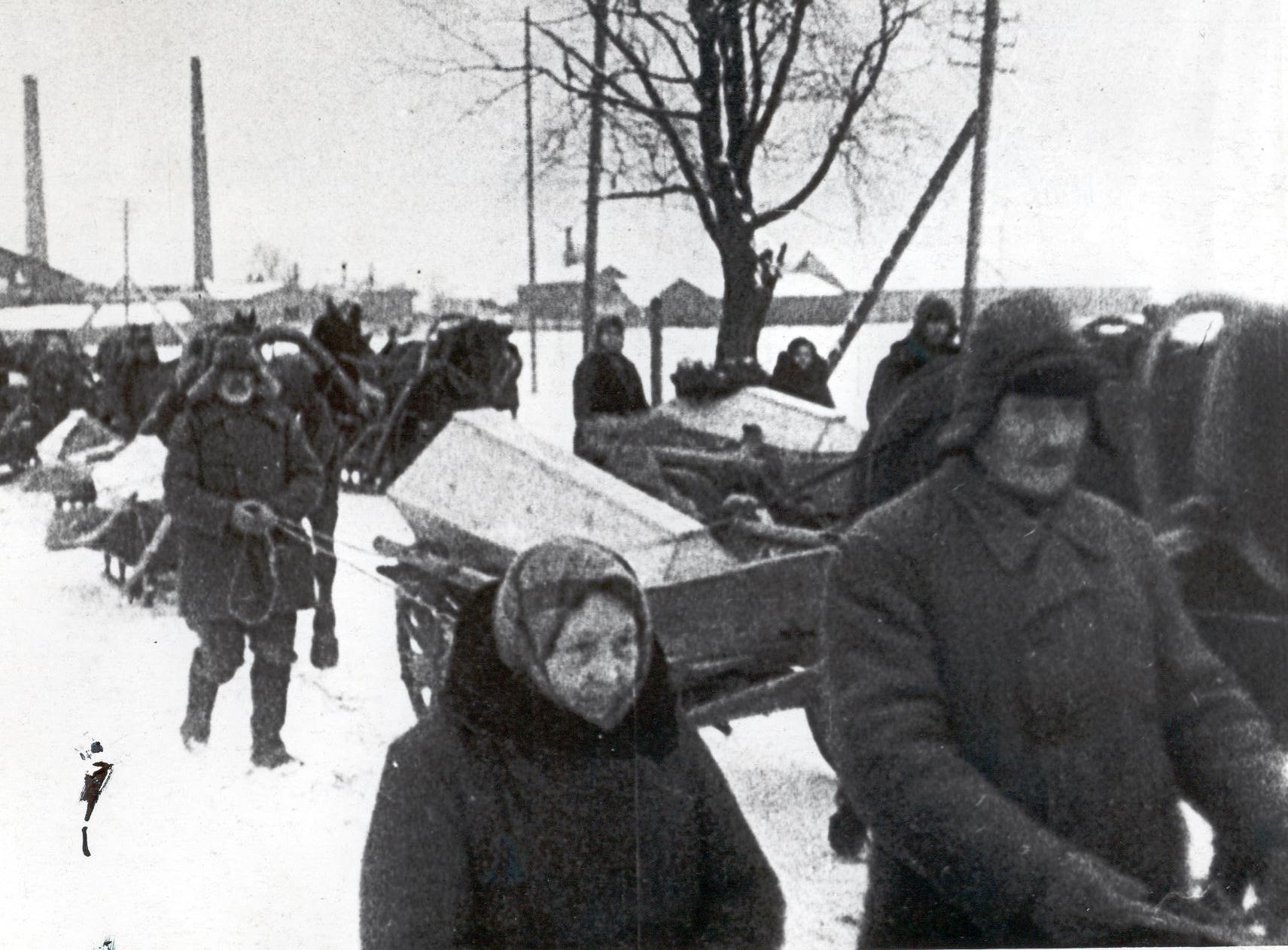 Foto. Fašismiohvrite ümbermatmine Võrus 3.detsembril 1944.a. Vaade matuserongile, regedele ja vankritele millel kirstud.