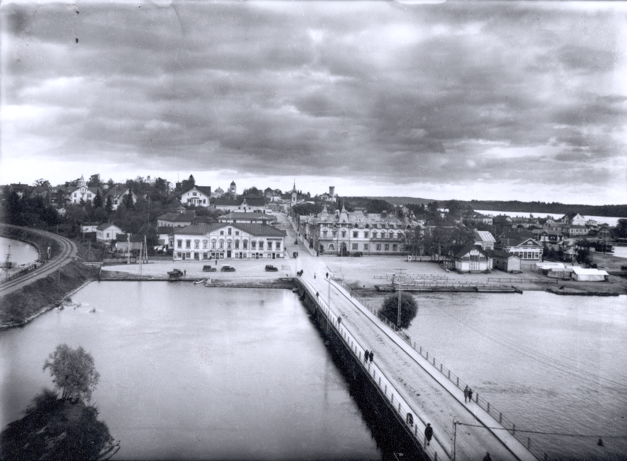 Näkymä Miljoonatalon yläkerrasta itään kohti I kaupunginosaa yli Haapasalmen. Vasemmalla rautatie, oikealla Linnankadun länsipää. Sikion talon ja Matkailijahotellin edessä autoja pirssissä. 1920-luku–1930-luku. View east from Miljoonatalo