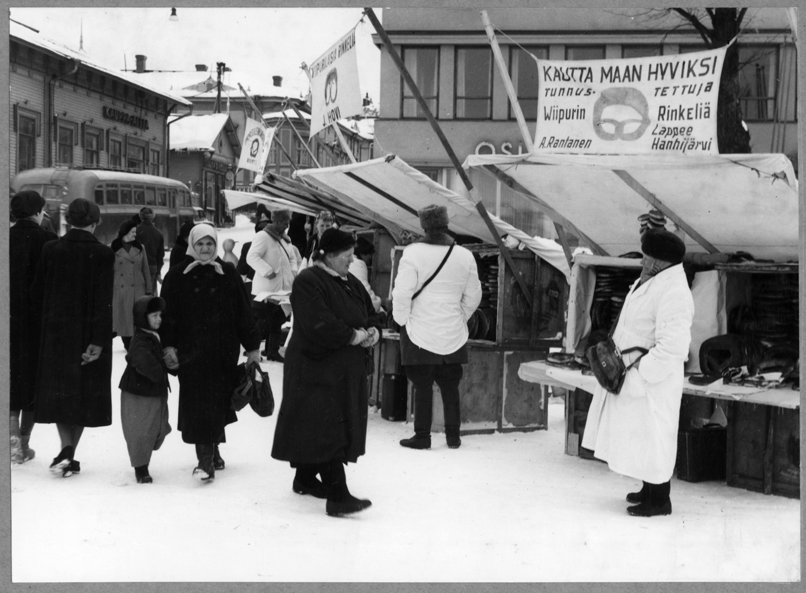 Tammikuun markkinat kauppatorilla. Viipurinrikelin myyjinä mm. A. Rantanen, Lappee Hanhijärvi ja J. Hovi. Vasemmalla Kauppa-Aitta-liike 1950-luku. January market in the market place