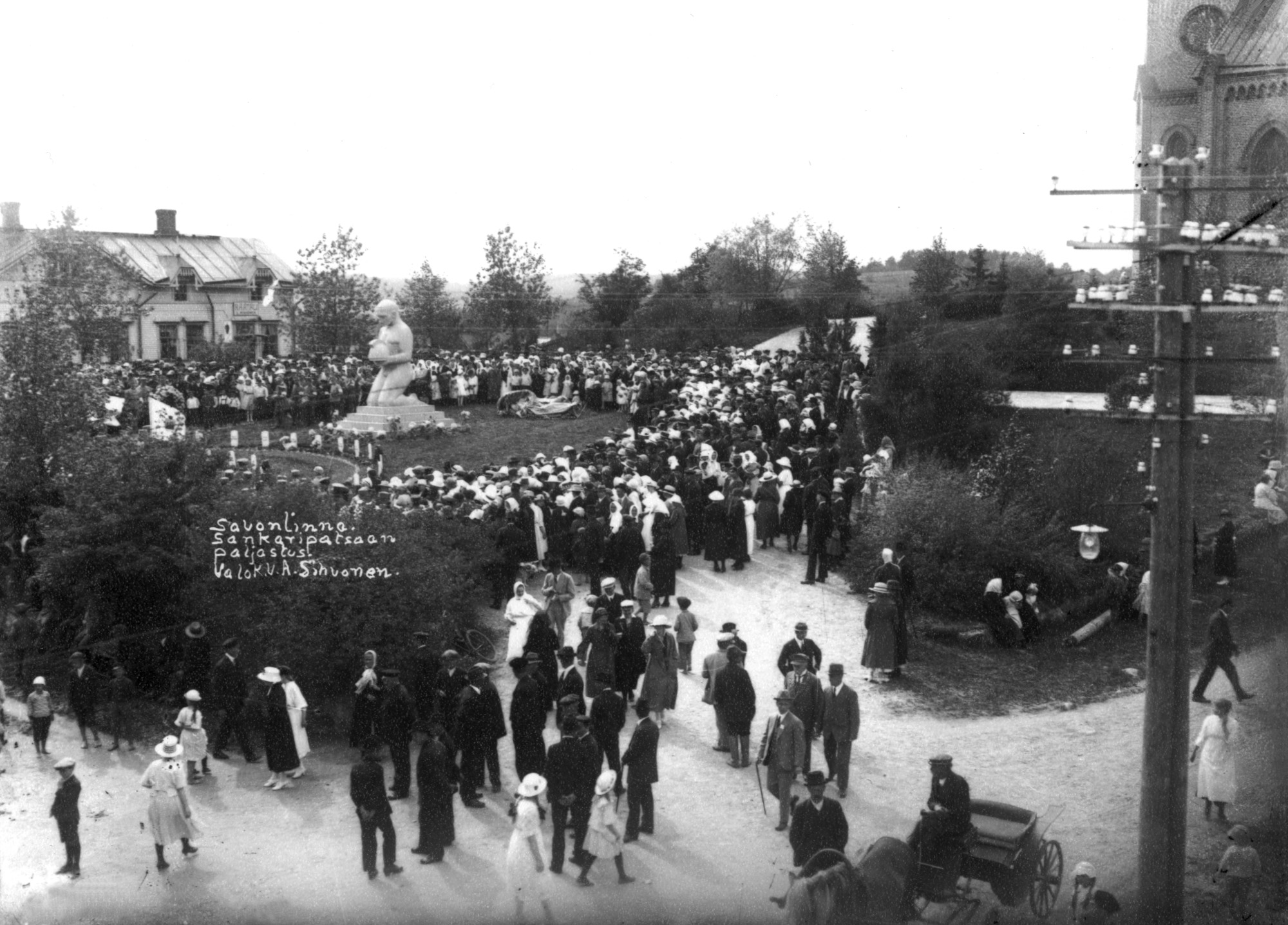 Yleisöä seuraamassa Vapaussodan muistomerkin (sankaripatsas) paljastustilaisuutta. Kuvassa taustalla, vasemmassa reunassa Sääminginkatu 6, oikeassa reunassa näkyy kirkko.	People following the unveiling of the memorial of the Finnish civil war