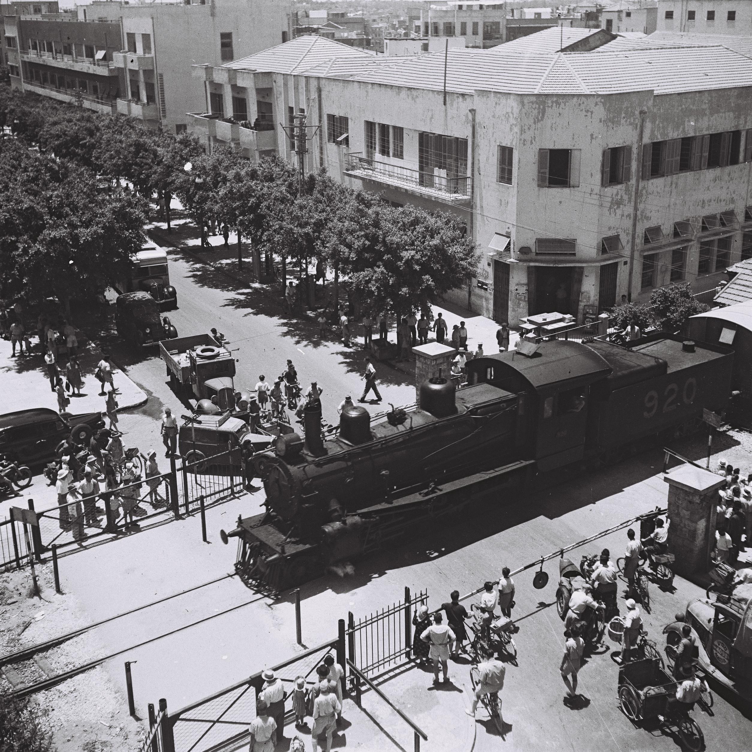 A LOCOMOTIVE CROSSING ALLENBY STREET IN TEL AVIV, NEAR THE MAIN POST OFFICE. קטר חוצה את רחוב אלנבי בתל אביב, ליד בניין הדואר המרכזי.D839-113