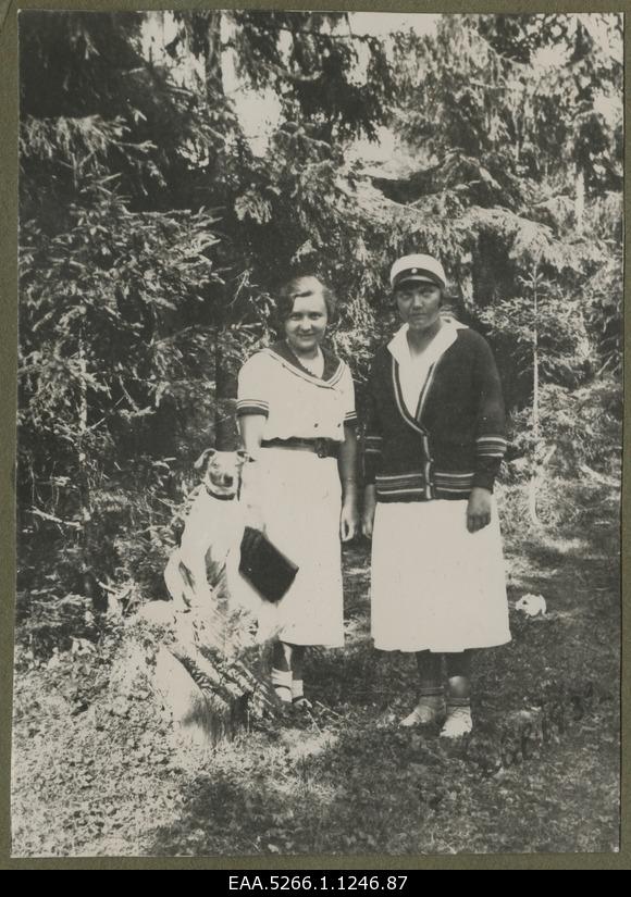 Benita Labi with a girlfriend and a dog, forest in the background.