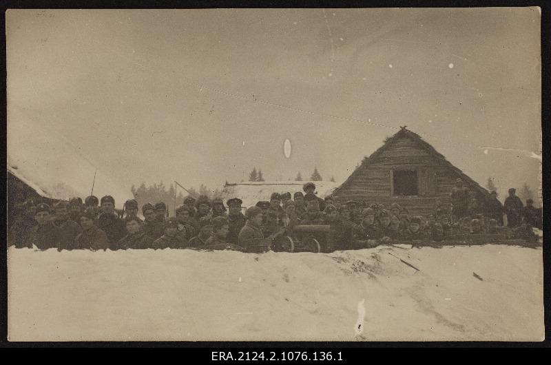 Group of military personnel [5. From the foot knee?] Group photo in positions cast behind the snow farm complex background