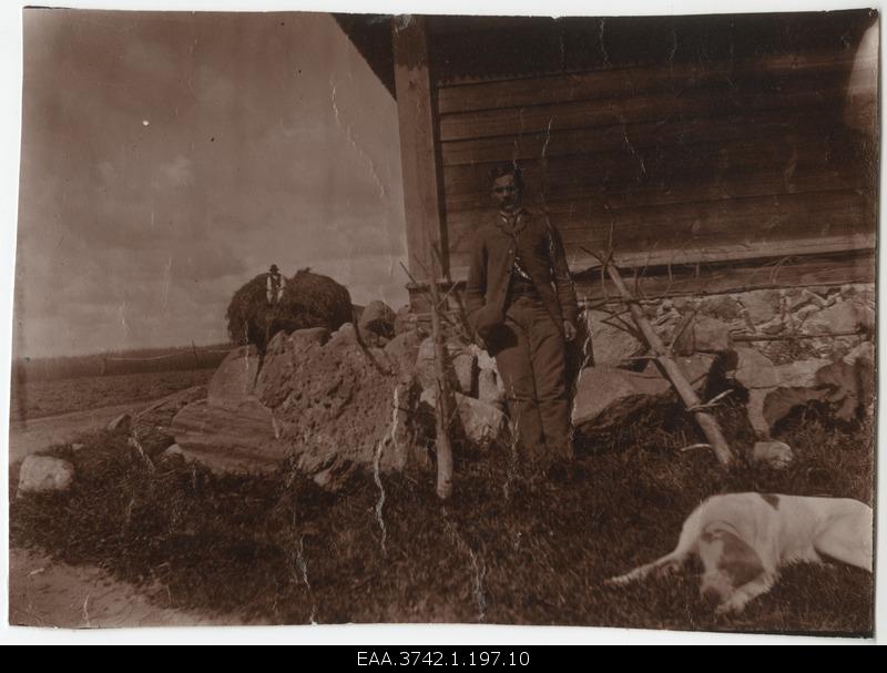 An employee of the eye clinic in front of the foundation of landstones in the farm building