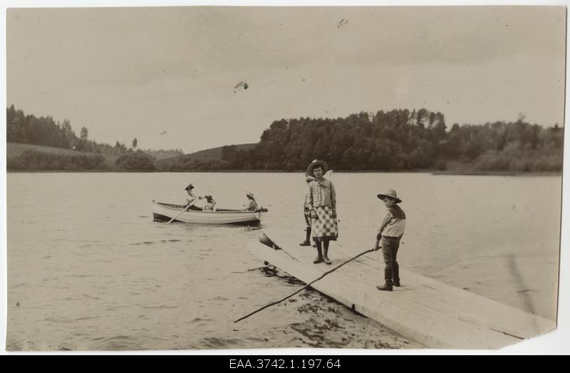 Family of Raehlmann and Kossmann children driving on a boat bridge and boat on Pühajärvi