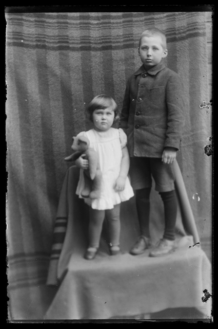 Laste rõivastus - poiss ja tüdruk toolil seismas