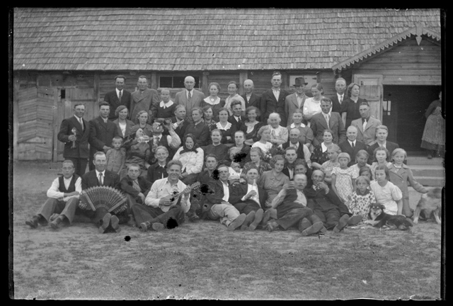Grupipilt - talumaja ees peoseltskond - naised, lapsed ja mehed pillidega