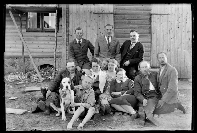 Meeste, naiste ja laste rõivastus - seltskond koeraga maja ees õues