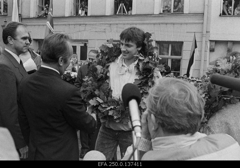 The first secretary of the Central Committee of the ECB, Vaino Väljas, congratulates the Soul Olympic winner, the basketball player Tiit Sokku, on the tribute to respect for the Olympics at the Raekoja Square.