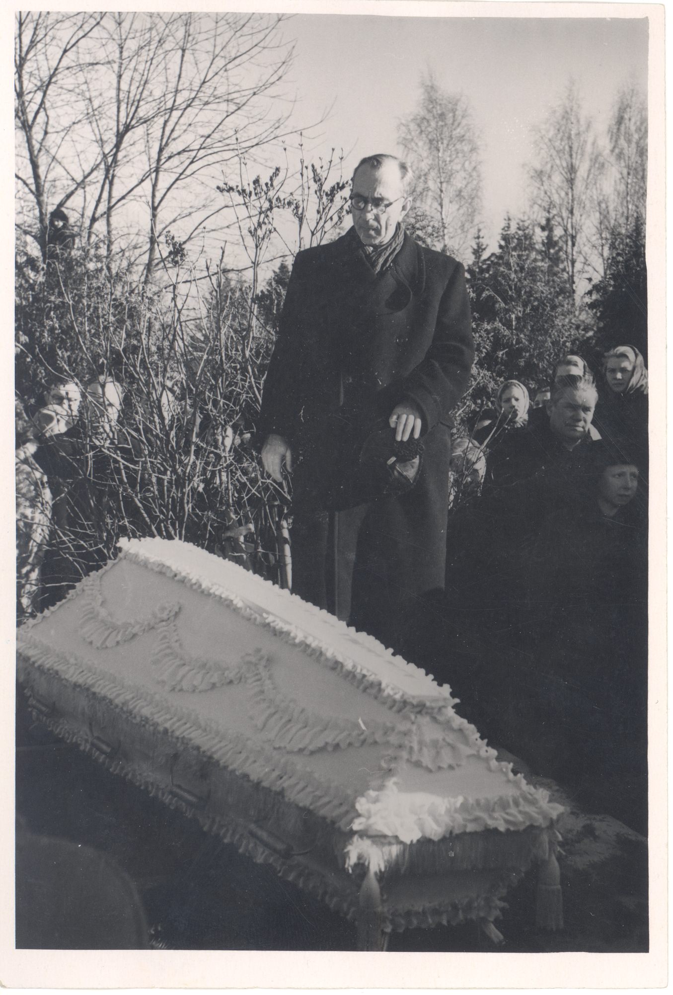 Anna Haava funeral on Tartu Maarja cemetery. Wooden shirt on the open grave. Mart Raud on the tomb.