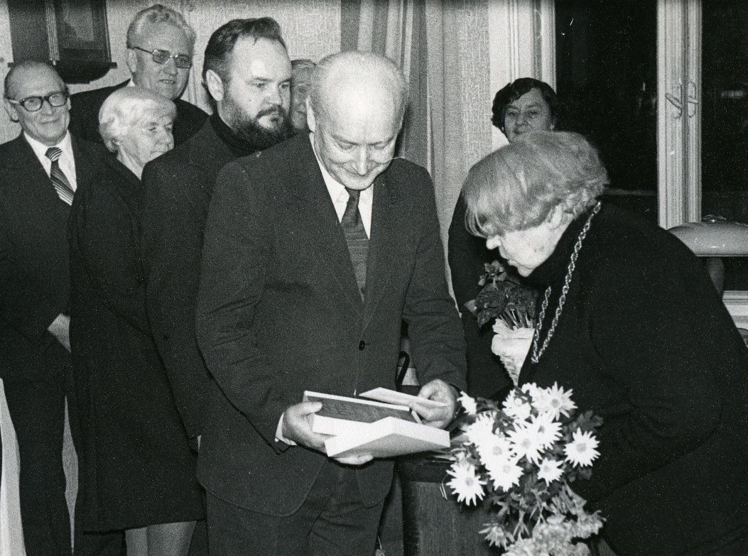 Betti Alver's 75th anniversary evening at the Tartu Writers' House 27th November 1981. Jubilari congratulates Kalju Kääri. Rear standing left: 1. Tõnis Lehtmets, 2. Renata Tamm, 3. UNO Leisner and others