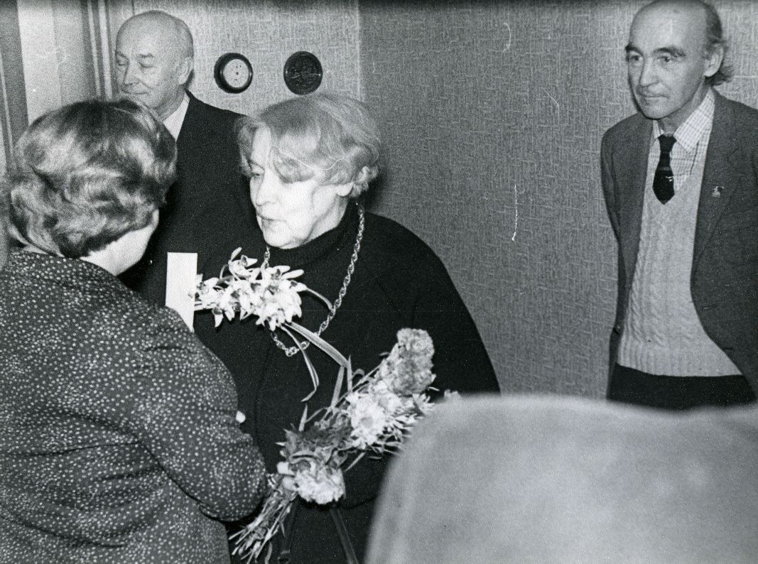 Betti Alver's 75th anniversary evening at the Tartu Writers' House 27th of November 1981. Poettess congratulates Ellen Niit, behind Kalju Kääri and Ain Kaalep