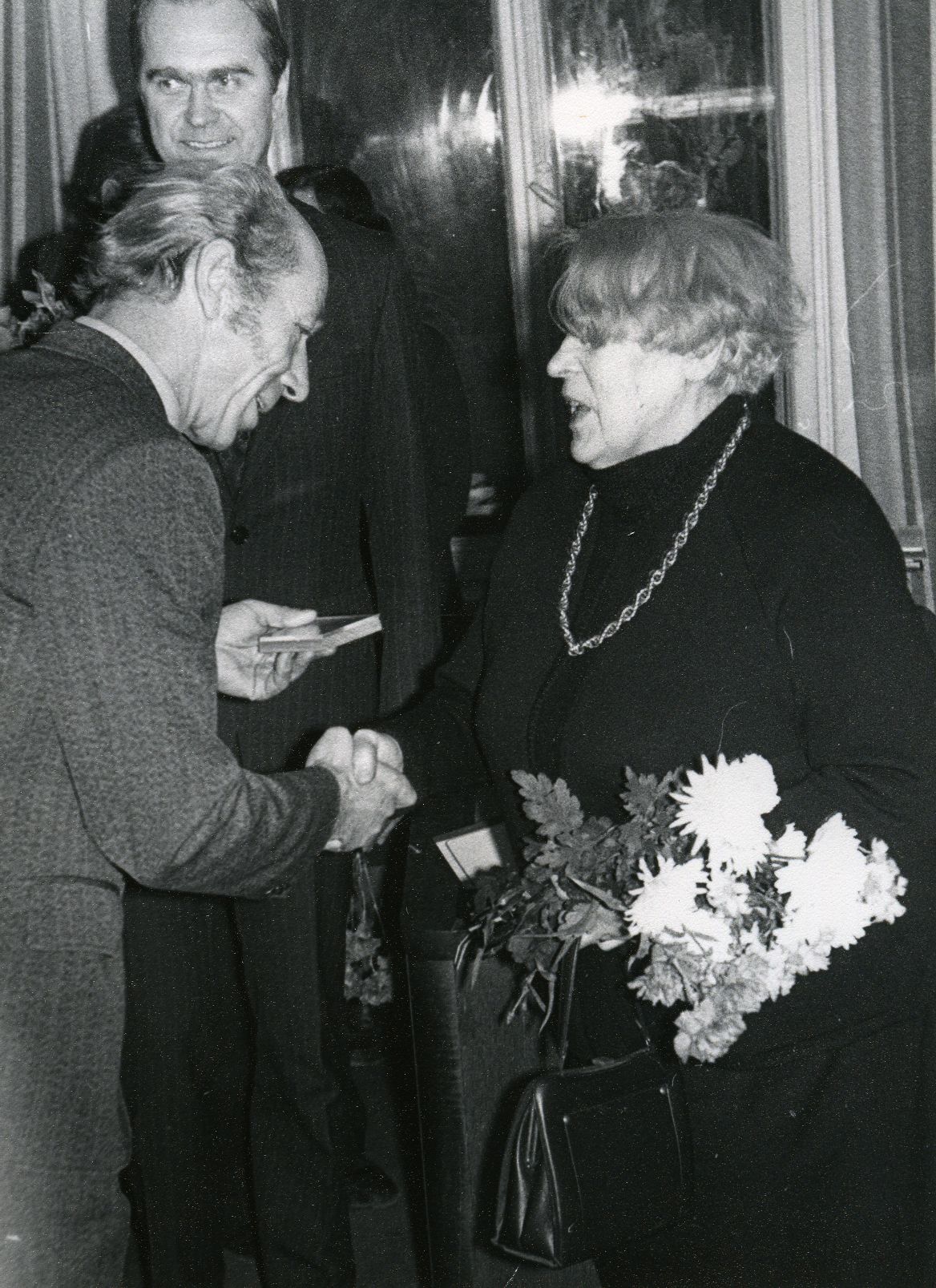 Betti Alver's 75th anniversary evening at the Tartu Writers' House on 27th November 1981. Poetess congratulates Nikolai Preiman. Behind Indrek Toome