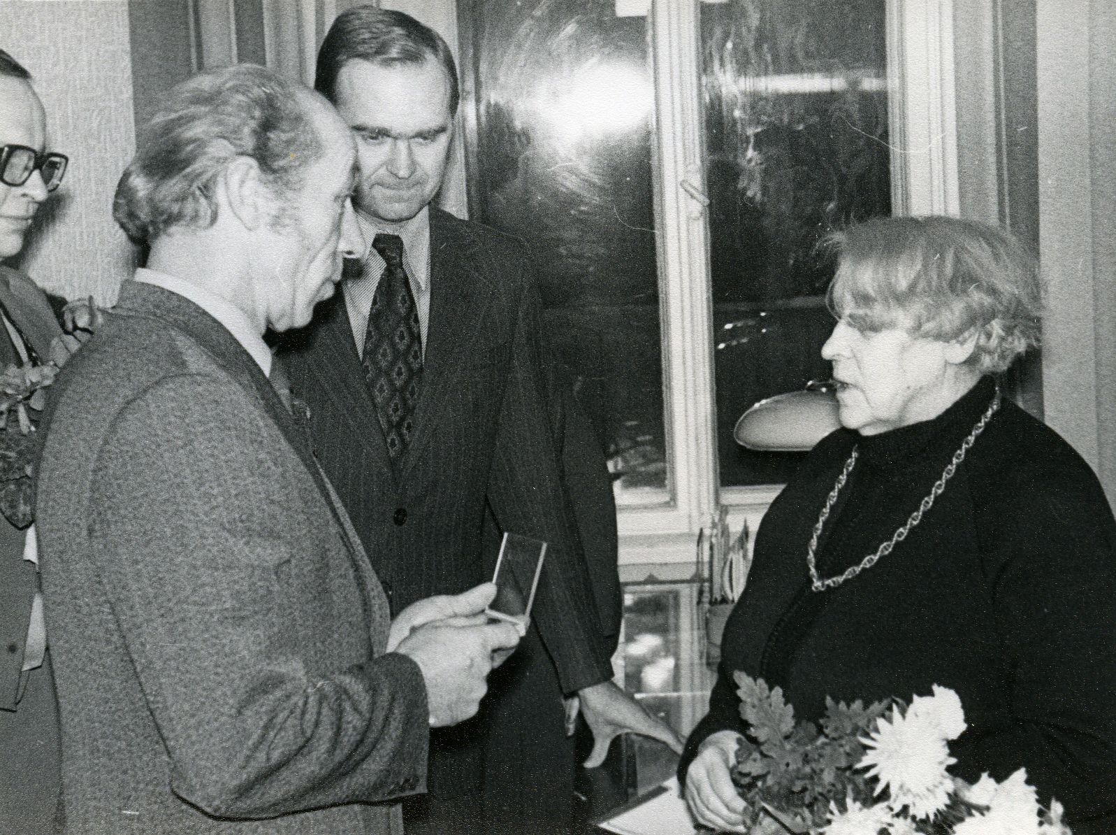 Betti Alver's 75th anniversary evening at the Tartu Writers' House on 27th November 1981. Poetess congratulates Nikolai Preiman. Behind Arno Allman and Indrek Toome