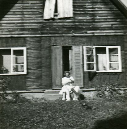 Betti Alver with a goat, sitting on the staircase of the house. 1952
