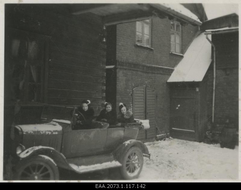 Pärnu schoolgirls sitting in the car in the house courtyard