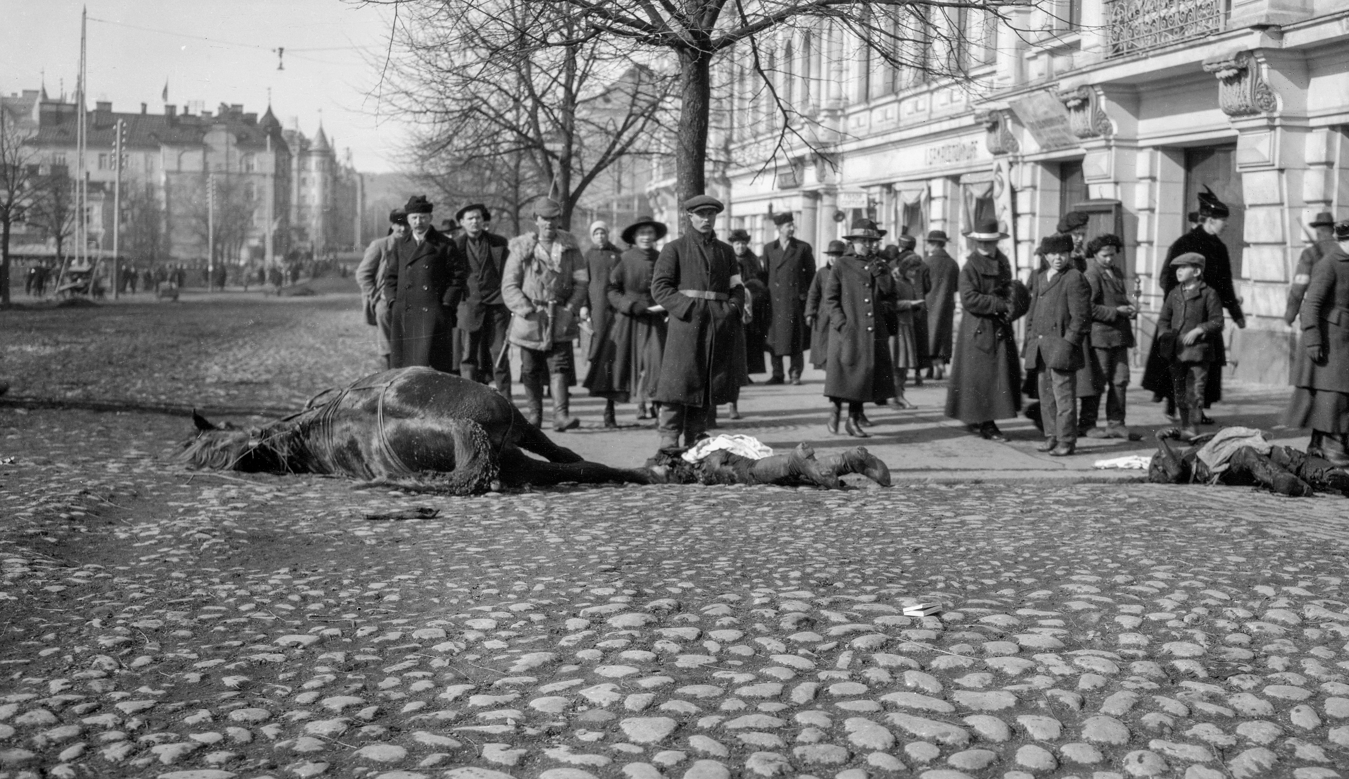 The burnt bodies of the Red Guards on the Hämeen Street of Tampere (26696844640) - Imaged on the corner of Hämeenkadu and Pellavatehtaankatu. Behind the house is Ruuskase. CC-BY Tampere 1918, photographer Oscar Sundberg, Vapriiki photo archive. Finnish Civil War 1918, Photographer Oscar Sundberg, Vapriikki Photo Archives.