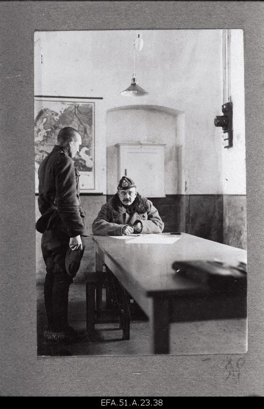 [6. The Chief of the Armed Forces, Colonel [Gustav Simmo] is conversing with the soldier.
