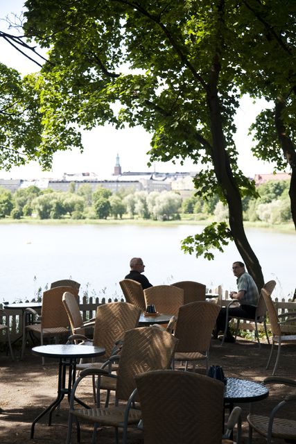 Blue Huvila Café, garden area; outlook, customers on the table, behind Töölönlahti