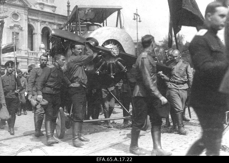 The Russian 12th Army Flight Saloon lost the pilot praporchchik (fairman) Jan Mahlpuu funeral procession, movement over the tramway, left blue-black-white flag, background Riga Russian theatre – later National Theatre.