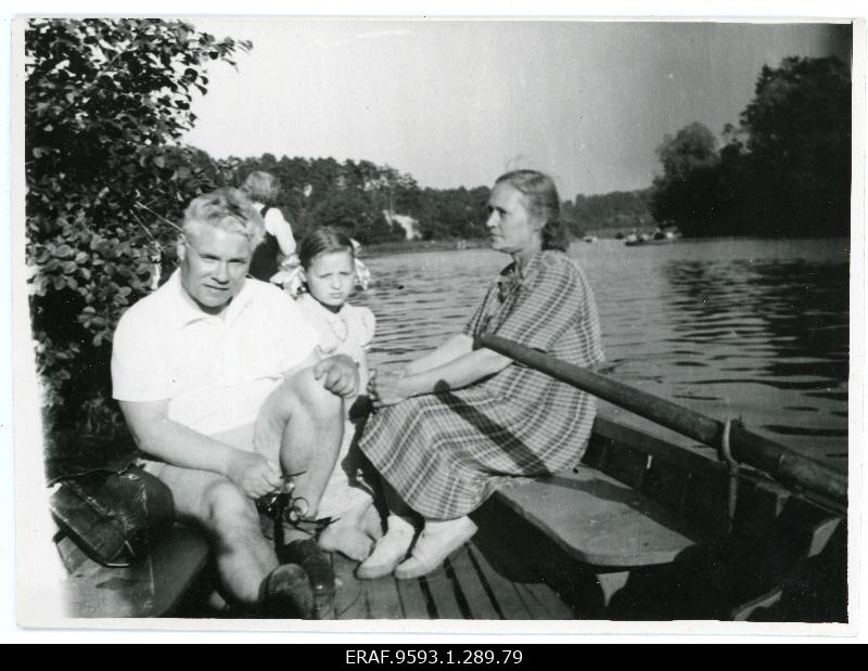 A man, woman and child are sitting on the boat.