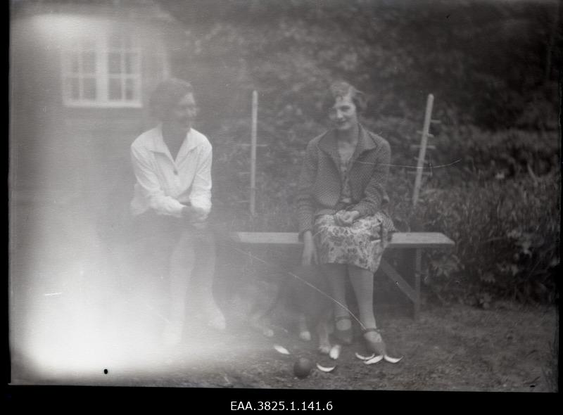 Two young women sitting on the garden bench