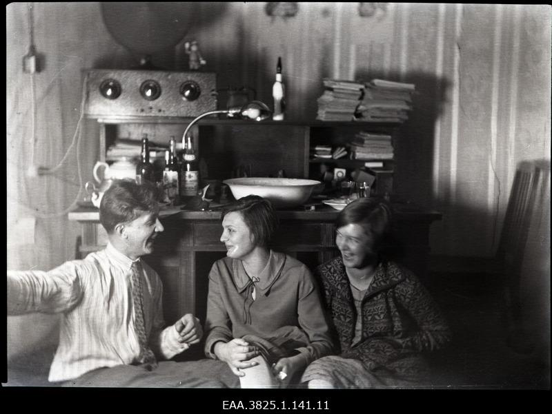 Two women and men sitting in the living room and chatting